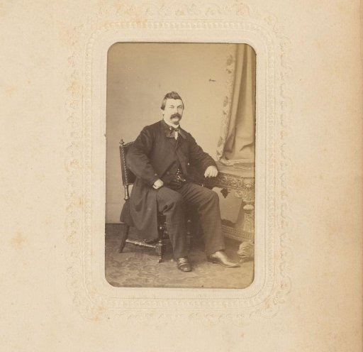 Portrait of a seated man with a moustache