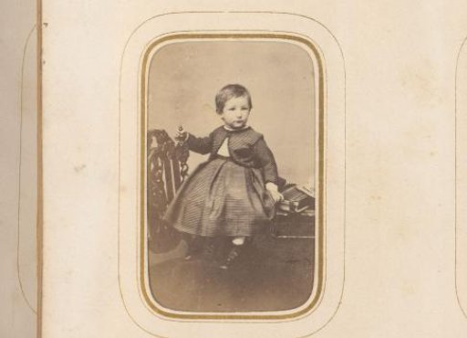 Portrait of a seated child with a photo album