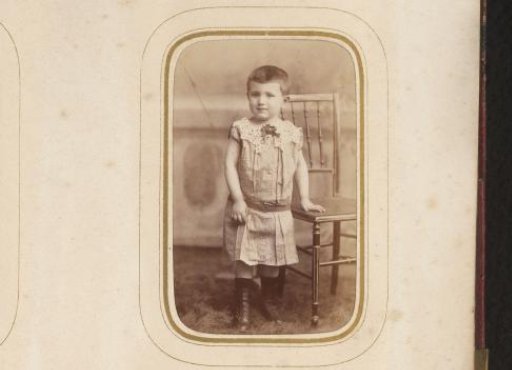 Portrait of a child standing by a chair