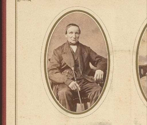 Portrait of a seated man with a walking stick in his hand