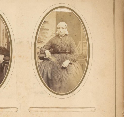 Portrait of a seated woman in a white traditional cap