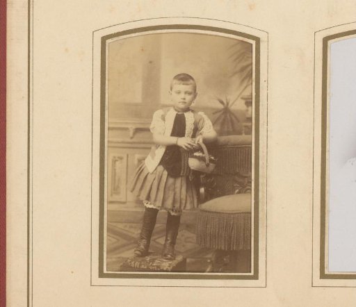 Portrait of a girl with short hair and earrings, standing on a footstool