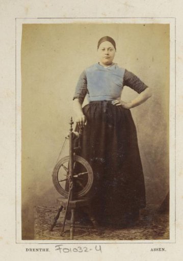 Portrait of an unknown woman with a spinning wheel in traditional costume of Assen, Drenthe