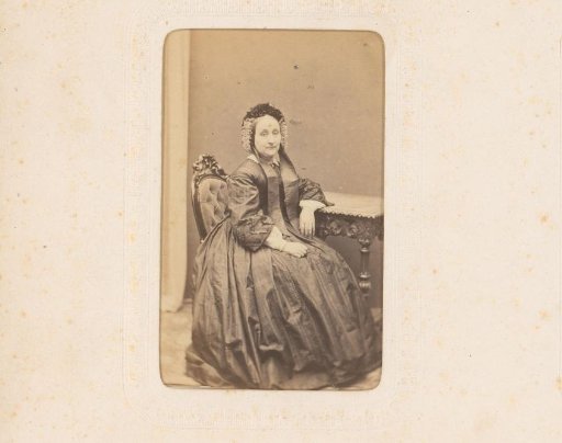 Portrait of a woman with a cap, seated at a table