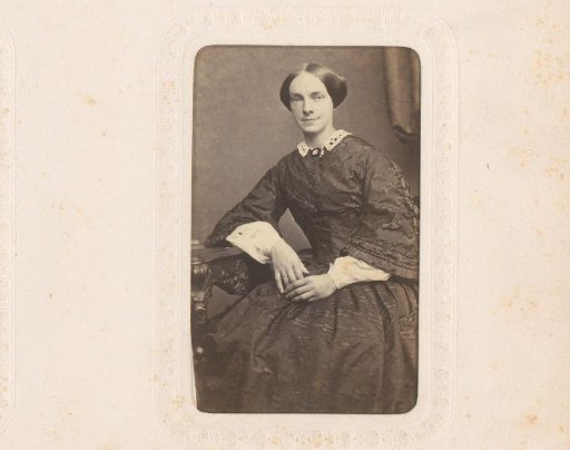 Portrait of a woman, seated at a table