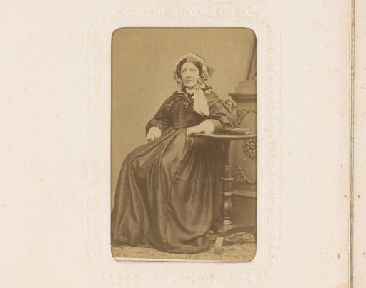 Portrait of a woman with a cap, seated at a table with a book