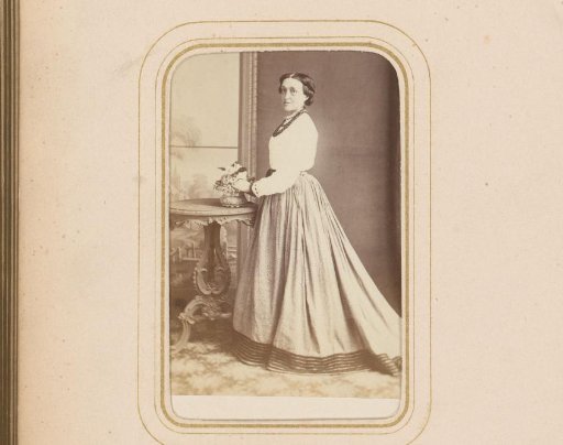 Portrait of a Woman Standing by a Table with Flowers