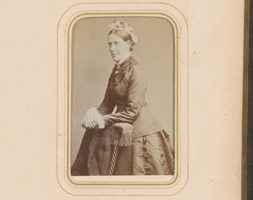 Portrait of a standing woman, leaning on the arm of a prayer stool