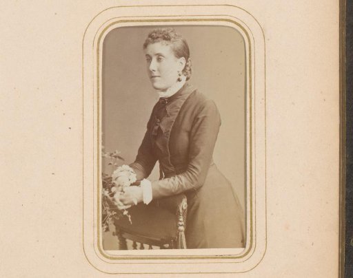 Portrait of a standing woman, leaning on the arm of a prayer stool
