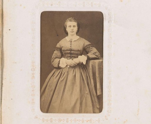 Portrait of a standing woman with earrings in a striped dress