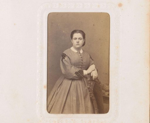 Portrait of a young woman, standing by a chair