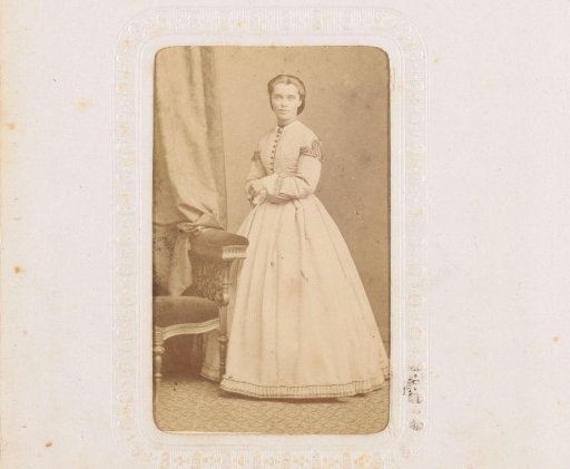 Portrait of a young woman, standing by a chair