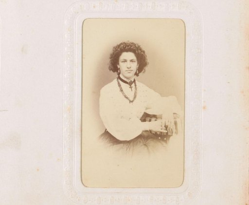 Portrait of a seated woman with necklaces, one of which has a cross