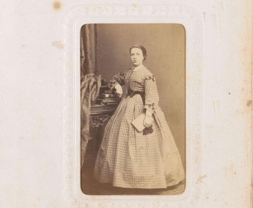 Portrait of a standing young woman holding a book