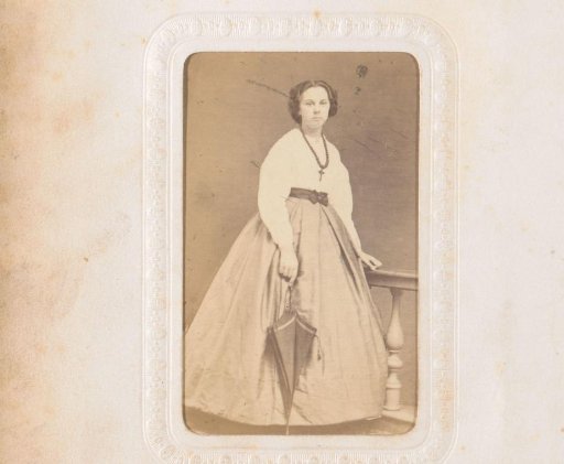Portrait of a young woman holding an umbrella, standing by a balustrade