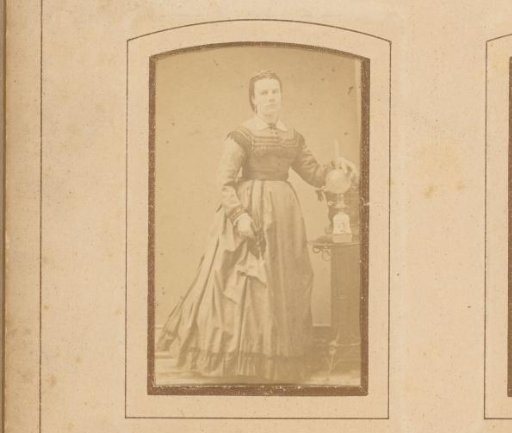 Portrait of a woman, standing by a table with an oil lamp