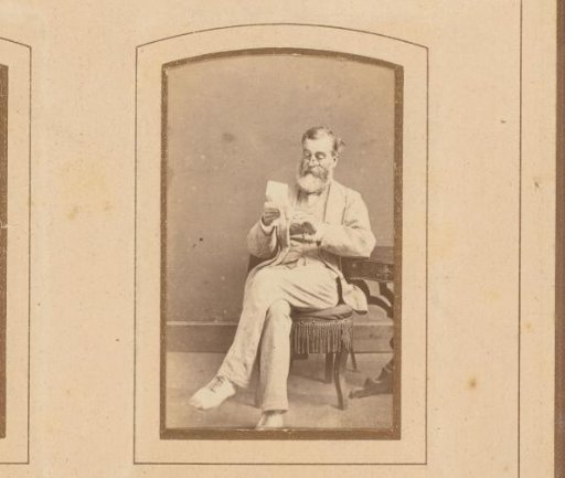 Portrait of a reading man with spectacles, seated at a table
