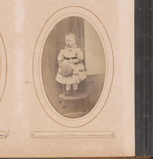 Portrait of a girl with a hat, standing on a chair