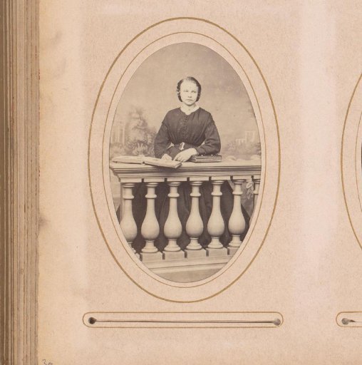 Portrait of a woman standing by a balustrade with books