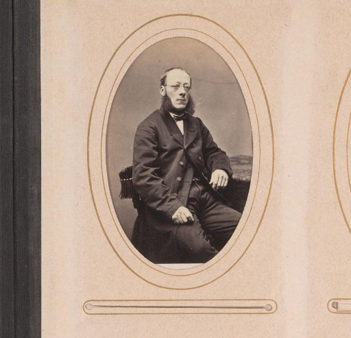 Portrait of a seated man with spectacles and sideburns
