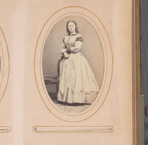 Portrait of a woman, standing by a chair