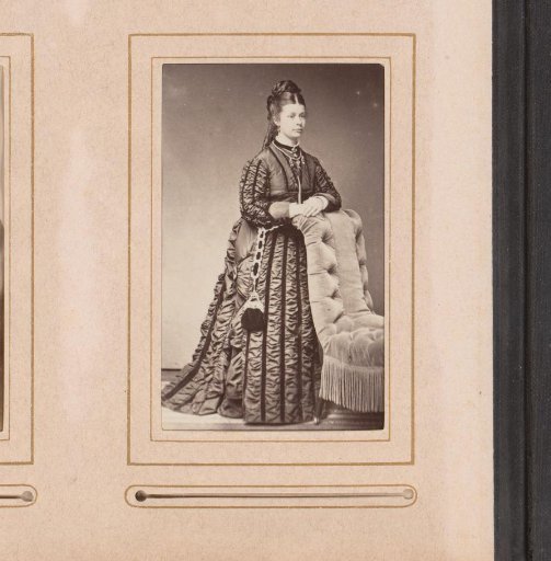 Portrait of a woman, standing by a chair