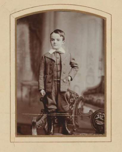 Portrait of a boy standing on a chair