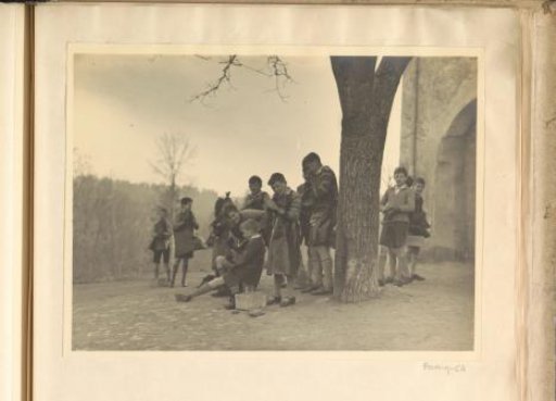 Young pupils polishing shoes under a tree in Hermannsberg, a branch of Schule Schloss Salem