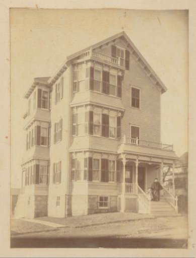 House with woman and child on the porch, presumably in Russia
