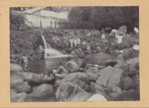 People among rock boulders on the bank of a river in the Dutch East Indies with Easter
