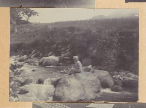 Woman sitting on a rock in a stream, presumably Kali Taman in Salatiga