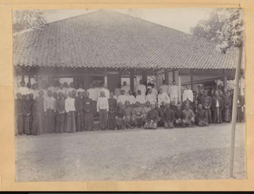 Group portrait of Indonesian and European men in front of a building in the Dutch East Indies