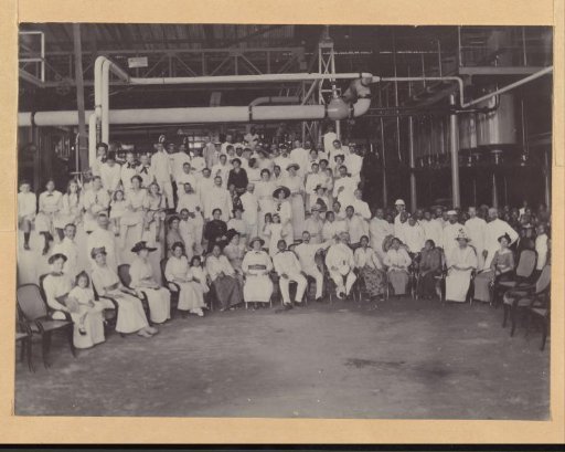 Group portrait of Indonesians and Europeans in a factory hall in the Dutch East Indies, presumably at a festive occasion