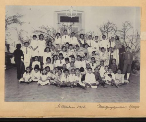 Group portrait of the children and caretakers of an orphanage in Jogjakarta with Sinterklaas and Zwarte Piet