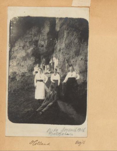 Group posing at rock dwellings, probably in the Southern Netherlands