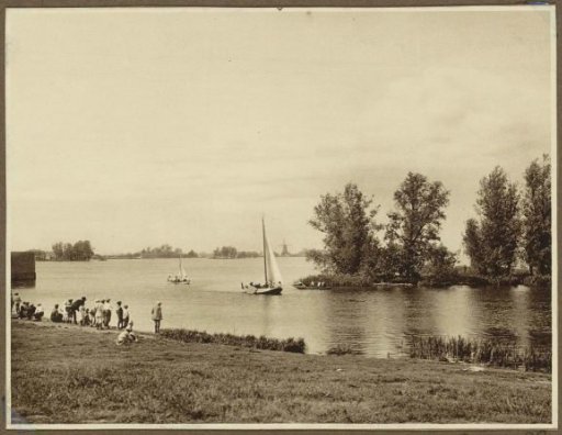 Public looking from the quay towards sailing ships on a pond, possibly near Amsterdam