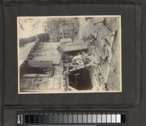 Woman and children at a loom in the Dutch East Indies