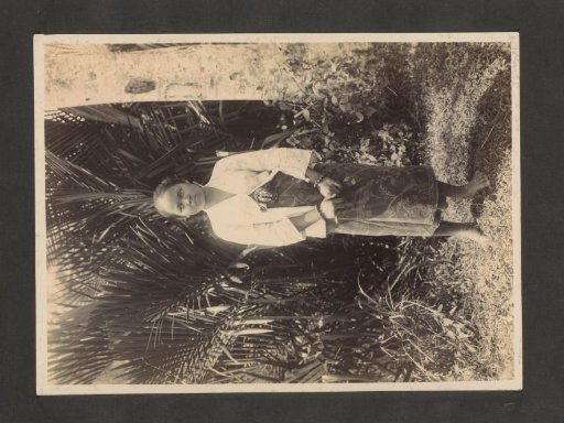 Young woman standing by a tree in the Dutch East Indies