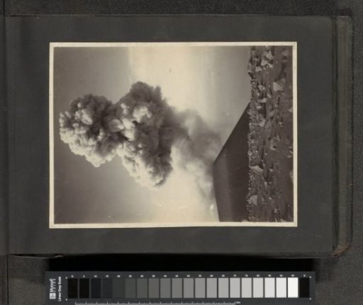 Smoking volcano with debris in the foreground in the Dutch East Indies