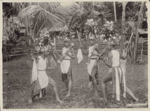 Indonesian boys in costumes dancing with kris in hand
