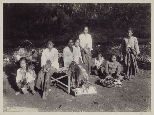 Women and children with goods displayed by the roadside