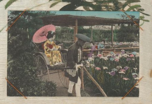 Japanese woman in a kimono in a rickshaw, two other women in the background in a pavilion