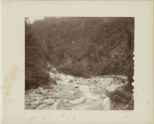 Stream with a road alongside and workers in the Dutch East Indies