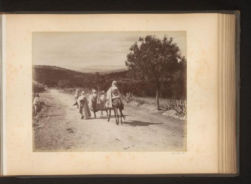 Men, one on horseback, on a road