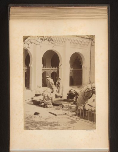 Men washing their faces or drinking in a courtyard