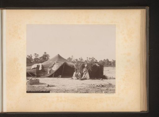 Two people in front of a dwelling in Algeria