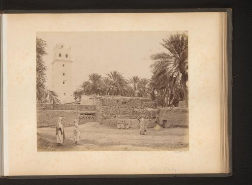 Figures by a wall with a tower in the background