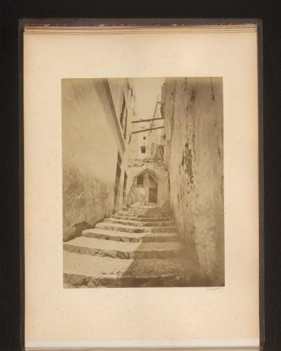 Man at the top of a staircase in an alley