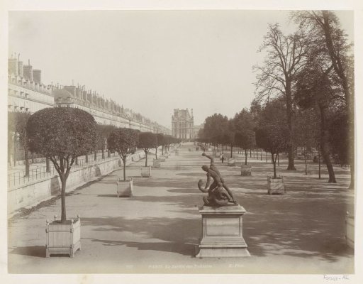 Jardin des Tuileries in Paris with potted trees and a statue, seen towards the Louvre