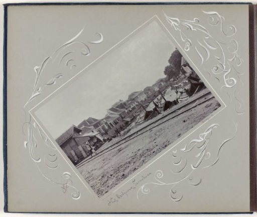 Inner harbour in Surabaya with houses, boats and railway line
